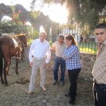 Señor Camerino Gonzalez with others on a sunny day outside near a horse